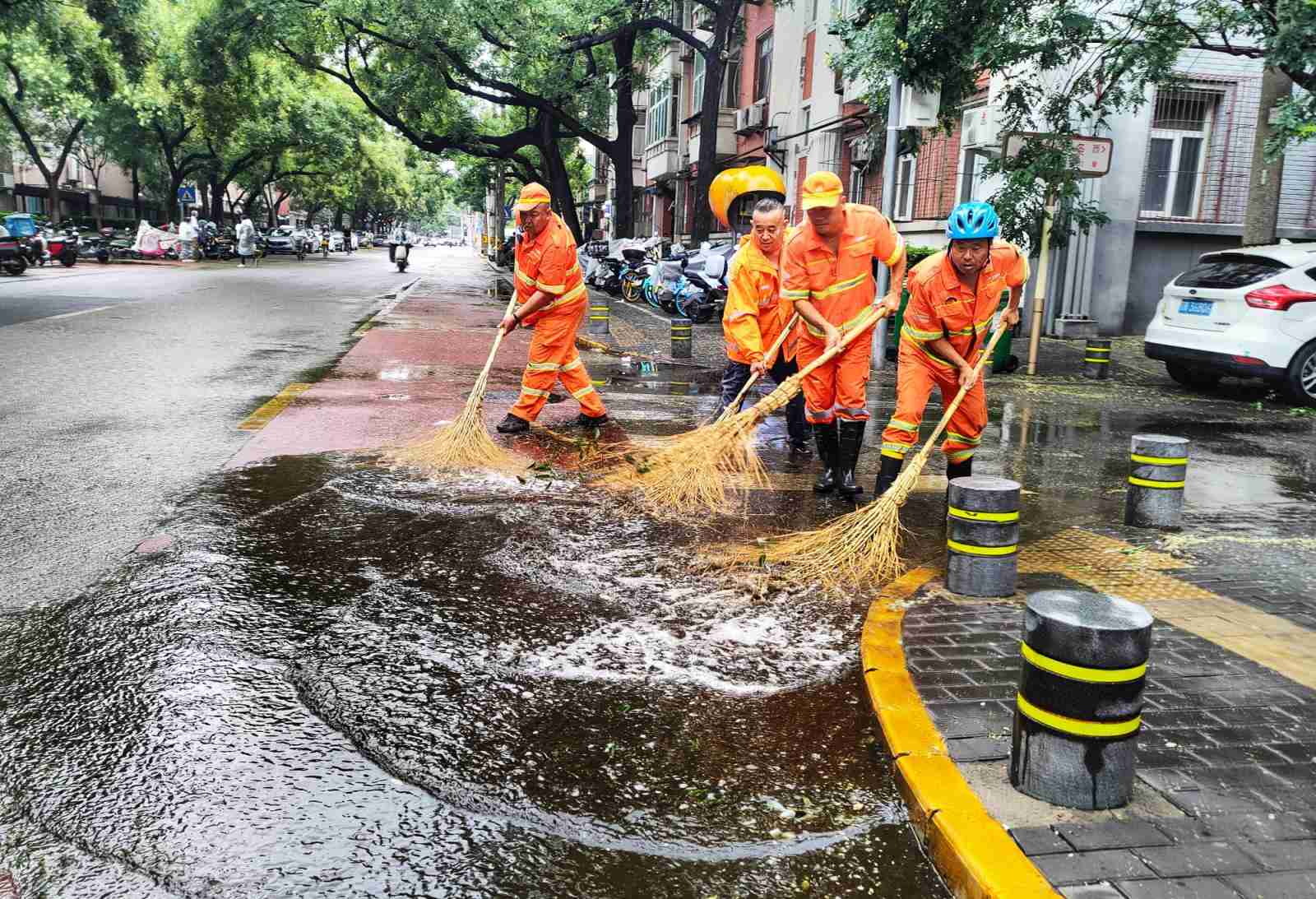 保障市民出行，环卫工人一早清理路面积水